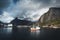 Reine, September 2018: Ship with rainbow in the background in the harbour of famous tourist attraction of Reine in