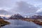 Reine, snow covered mountains in the background and the fishing cabins Rorbu in the foreground, Lofoten Islands, Norway