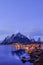 Reine, snow covered mountains in the background and the fishing cabins Rorbu in the foreground, Lofoten Islands, Norway