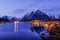 Reine, snow covered mountains in the background and the fishing cabins Rorbu in the foreground, Lofoten Islands, Norway