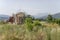 reinforcements on remains of building engulfed by lush vegetation, Amatrice, Italy