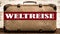 REISEN HINTERGRUND - Alter rustikaler vintage Koffer mit rotem Banner und weiÃŸem Schriftzug