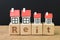 Reit, Real estate investment trust concept, miniature houses on cube wooden block with alphabet combine the word Reit on dark