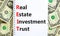 REIT real estate investment trust symbol. Concept words REIT real estate investment trust on note on beautiful white background.