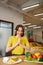 Rejoicing young girl in yellow blouse looking at fresh vegetables