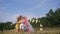 Relations of children, little friends hug each other in forest glade decorated with wigwam while relaxing in countryside