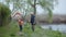Relationship, cheerful grandfather helps beloved grandson launch kite during joint holiday on river bank
