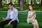 Relationship problem. Bored millennial couple using phones on dull date in park