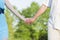 Relationships Concepts. Closeup of Hands of Caucasian Mature Couple Walking together Outdoors in Summertime