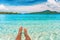 Relax feet selfie woman lying in turquoise crystalline blue water on French Polynesia motu beach vacation summer. Woman