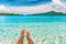 Relax feet selfie woman lying in turquoise crystalline blue water on French Polynesia motu beach vacation summer. Woman