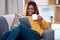 Relax, portrait and happy black woman with tablet on a sofa with website scroll on coffee break at home. Digital, search