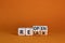 Relax and reopen symbol. Businessman turned cubes and changed the word `relax` to `reopen`. Beautiful orange table, orange