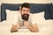 Relax and rest. Full of energy. Coffee affects body. Man handsome hipster relaxing on bed with coffee cup. Bearded