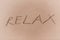 Relax Sign on a Yellow Sand Beach.