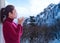 Relax style. Asian woman with red sweater fresh morning drinking hot coffee and looking out the window for see snow winter on the