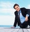 Relax, thinking and sea with a business man on a pier against a blue sky background for company vision. Smile, idea and