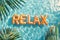 Relax word spelled out in inflatable pool floats in a summer holiday swimming pool