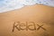 Relax written into the sand on a beach