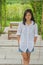 Relaxation Concept : Asian woman wear white shirt standing on cement floor at outdoor garden.