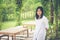 Relaxation Concept : Asian woman wear white shirt standing on grass at outdoor garden and smiling with relaxing.