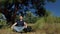 Relaxation and meditation in nature. Man meditates under a pine tree.