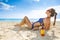 Relaxed active woman in swimwear on seashore with sun cream