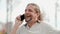 Relaxed attractive middle aged man with long gray hair speaks on smartphone, laughs and smiles.