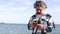 Relaxed bearded man on the seashore while chatting on a smartphone