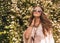 Relaxed bohemian young woman among flowers