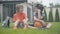 Relaxed Caucasian schoolboys sitting on green grass at home and talking. Portrait of joyful boys with basketball ball