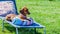 Relaxed dachshund sitting comfortably on a cushion on a sunbathing lounge chair