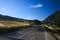 Relaxed driving on lonely road in the high plains of Sierra Nevada under blue sky