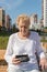 Relaxed elder woman sitting on a bench and looking in wallet