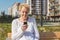 Relaxed elder woman sitting on a bench with smartphone. Happy old age concept