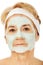 Relaxed elderly woman in facial mask