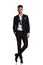 Relaxed elegant man in tuxedo standing with legs crossed