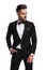 Relaxed elegant man in tuxedo stands with hand in pocket