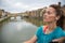 Relaxed fitness woman listening music in front of ponte vecchio