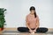 Relaxed focused woman practices yoga, doing butterfly asana, turnig soles upward