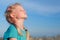 Relaxed girl breathing fresh air over blue sky on sea at summer. Dreaming, freedom and traveling concept