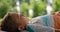 Relaxed guy lying on blanket closeup. Calm boy look up lounging on green grass.