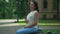 Relaxed happy Caucasian pregnant woman sitting on bench in city stroking belly in slow motion thinking. Side view