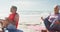 Relaxed hispanic senior couple practicing yoga on mats on beach