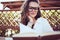 Relaxed housewife in shirt sitting at table reading book