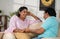 Relaxed indian middle aged couple talking spending time by talking each other on sofa at home - concept of communication