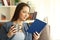 Relaxed lady reading a book and holding a mug