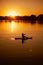 Relaxed lady silhouette sup boarding with paddle in hands on evening lake with stunning sunset in background covering