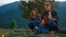 Relaxed lovers play guitar on nature view. Hikers couple spend vacation outdoors