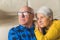 Relaxed loving married elderly man and woman hugging and looking away, wife resting on her husband's shoulder while